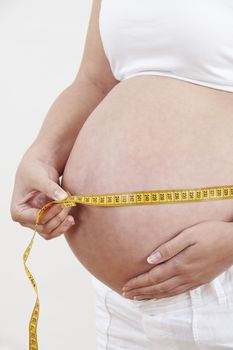 Close Up Of Pregnant Woman Measuring Waist