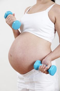 Close Up Of Pregnant Woman Exercising With Weights