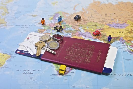 British Passport flight ticket and personal belongings displayed on a world map. Travel and vacation