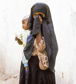 HADHRAMAUT, YEMEN - MAY, 15: arabic unknown mother carries her baby in a  wraparound garment on May 15, 1993 in Hadhramaut, Yemen. in 2008 still 62 percent of women in rural areas are  illiteracy.