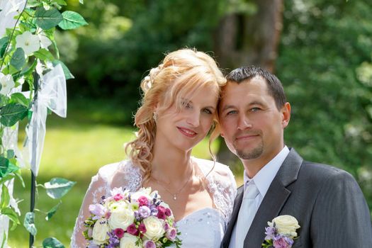 beautiful young wedding couple in park, blonde bride and her groom