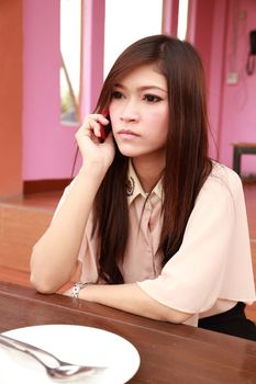 woman talking on the mobile phone, looking worried (at restaurant) 