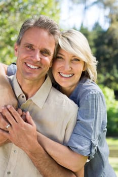 Portrait of smiling couple embracing in park