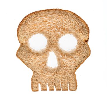 Skull shaped piece of bread cut from whole wheat loaf to illustrate danger from gluten in wheat products