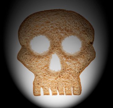 Skull shaped piece of bread cut from whole wheat loaf to illustrate danger from gluten in wheat products