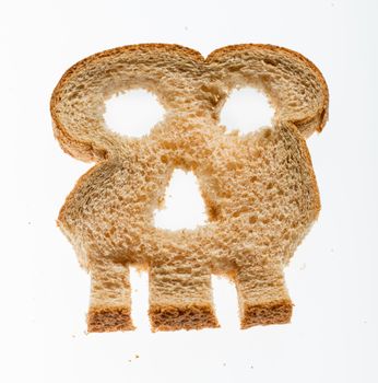 Skull shaped piece of bread cut from whole wheat loaf to illustrate danger from gluten in wheat products