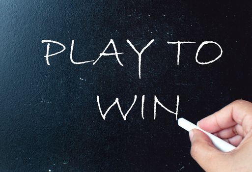 Play to win handwritten on a chalkboard