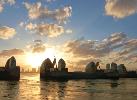 London River Thames barrier flood defenses with Canary Wharf skycrapers in the distance 