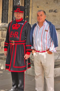 Beefeater, guard at the Tower of London, with a tourist