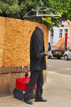 Human statue without face and umbrella at Portobelllo in London