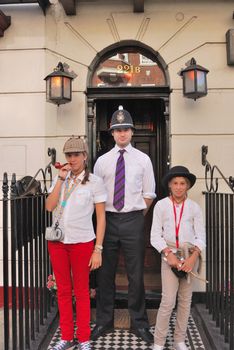 Girls and a Policeman actor outside the Sherlock Holmes Museum in London.