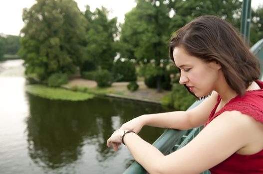 beautiful young woman standing on bridge