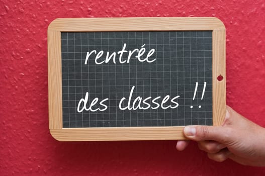 Chalkboard in hand - back to school -text in french