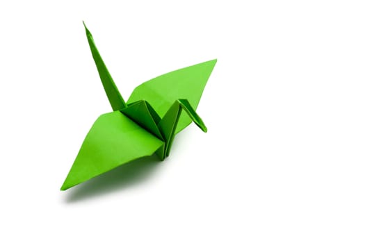 green origami paper crane on white paper background