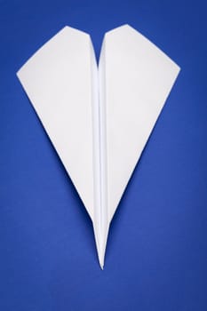 white paper plane on blue paper background