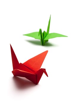 red and green origami paper crane on white paper