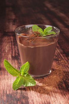Delicious pudding with fresh mint on wooden background. Culinary sweet dessert eating. 