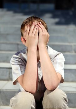 Sad and Troubled Kid sitting on the Stairs outdoor