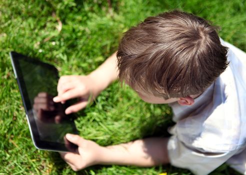 Kid with Tablet Computer on the Summer Meadow