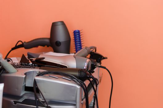 hairdressers accessories comb, brush, dryer and other lie neatly on plastic shelf