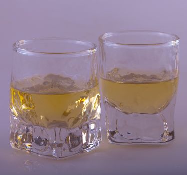 Two shots of whisky over gray background