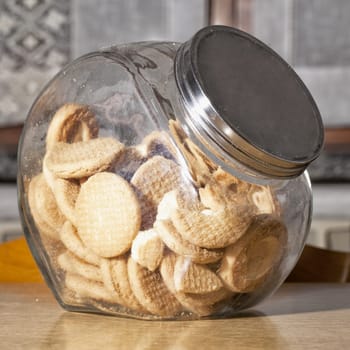 Glass full of biscuits over kitchen table