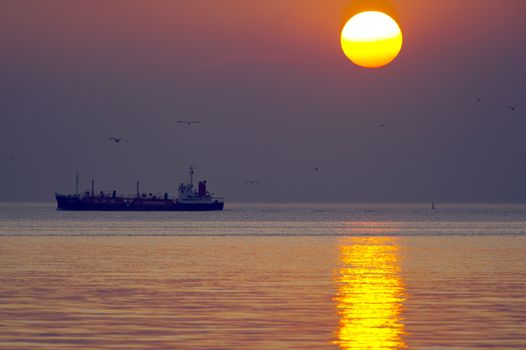 Bulk-carrier ship at sunset in the sea