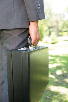 Cropped image of businessman carrying briefcase in park