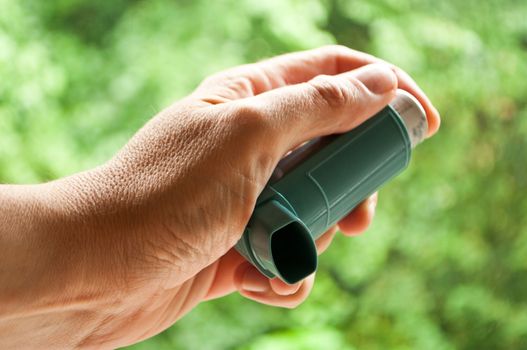 hand with asthma aerosol closeup