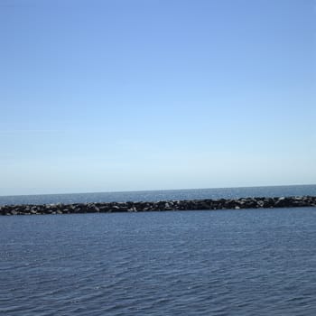 Large stone wall on a blue lake