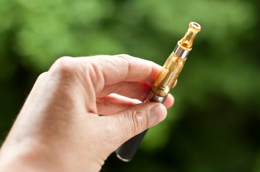 e-cigarette with hand closeup in outdoor