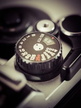 Macro photo of the shutter knob of an old 35mm film camera. Filtered to look vintage.