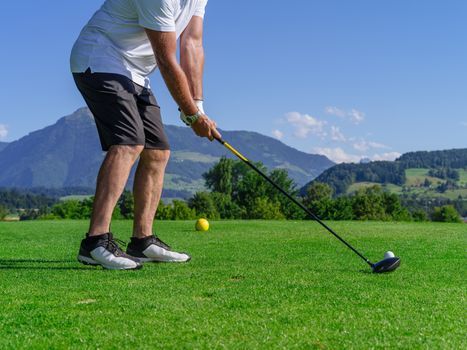Photo of a male golfer about to tee off on the golf course.