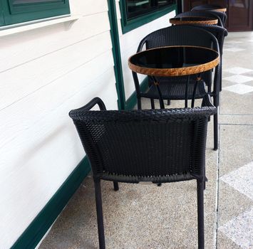 Tables and chairs placed on the outside of the coffee shop.                               