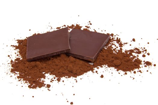 Squares of chocolate with cocoa powder on white background