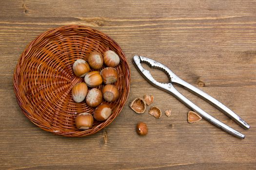 Hazelnuts and nutcracker on wooden table