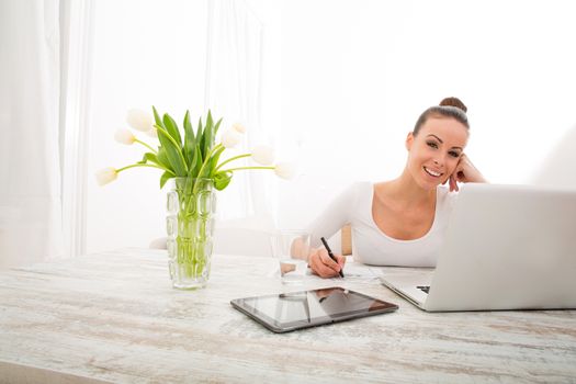 A young woman working from home with a laptop computer.