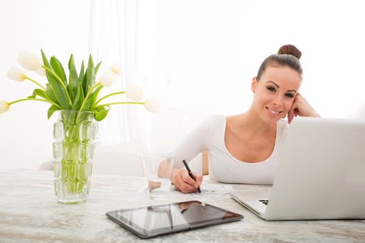 A young woman working from home with a laptop computer.
