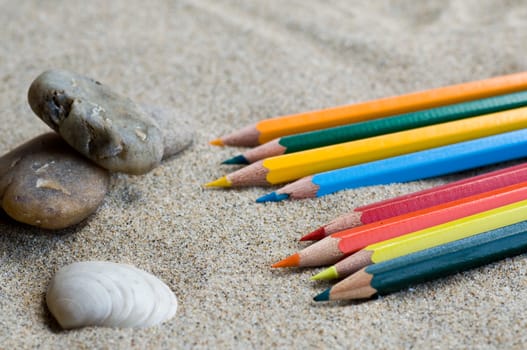 school supplies pencils colors on the beach