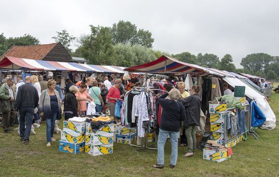 HELLEVOETSLUIS,NETHERLANDS-JULY 12, 2014: People shopping on the anual farmers market in Hellvoetsluis on July12,this market is only once a year and selling clothes and fresh food