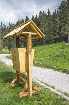 Wooden trash can in park, near forest