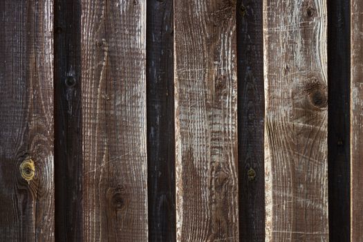 Background, vertical dark brown with natural yellow spots fence Board