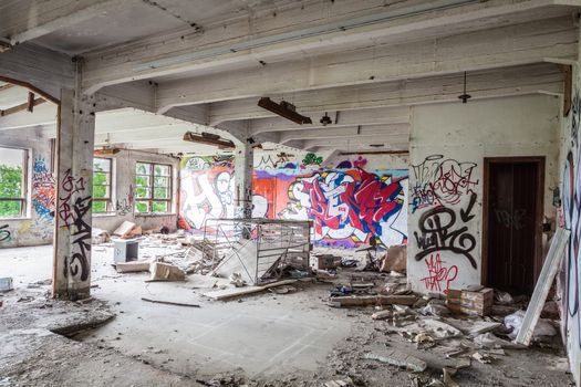 Messy abandoned factory room and graffitis