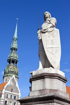 Statue of Saint Roland with St. Peter's church in the background in riga, Latvia.