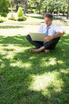 Full length of businessman surfing on laptop in park