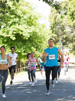 Group of athletes running in marathon on street