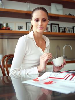 young successful woman, enjoying a cup of coffee in her home