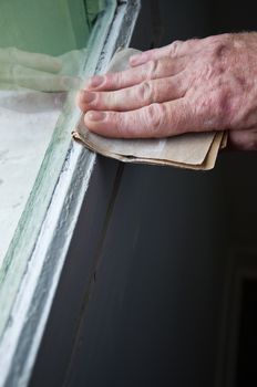 painting renovation -man with sandpaper closeup