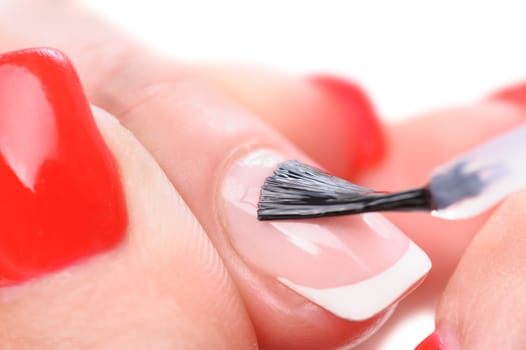 manicure applying, brushing fingernails with clear enamel