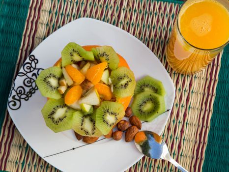 Exotic fruit salad in the orange skin and a glass of fresh orange juice.Top view